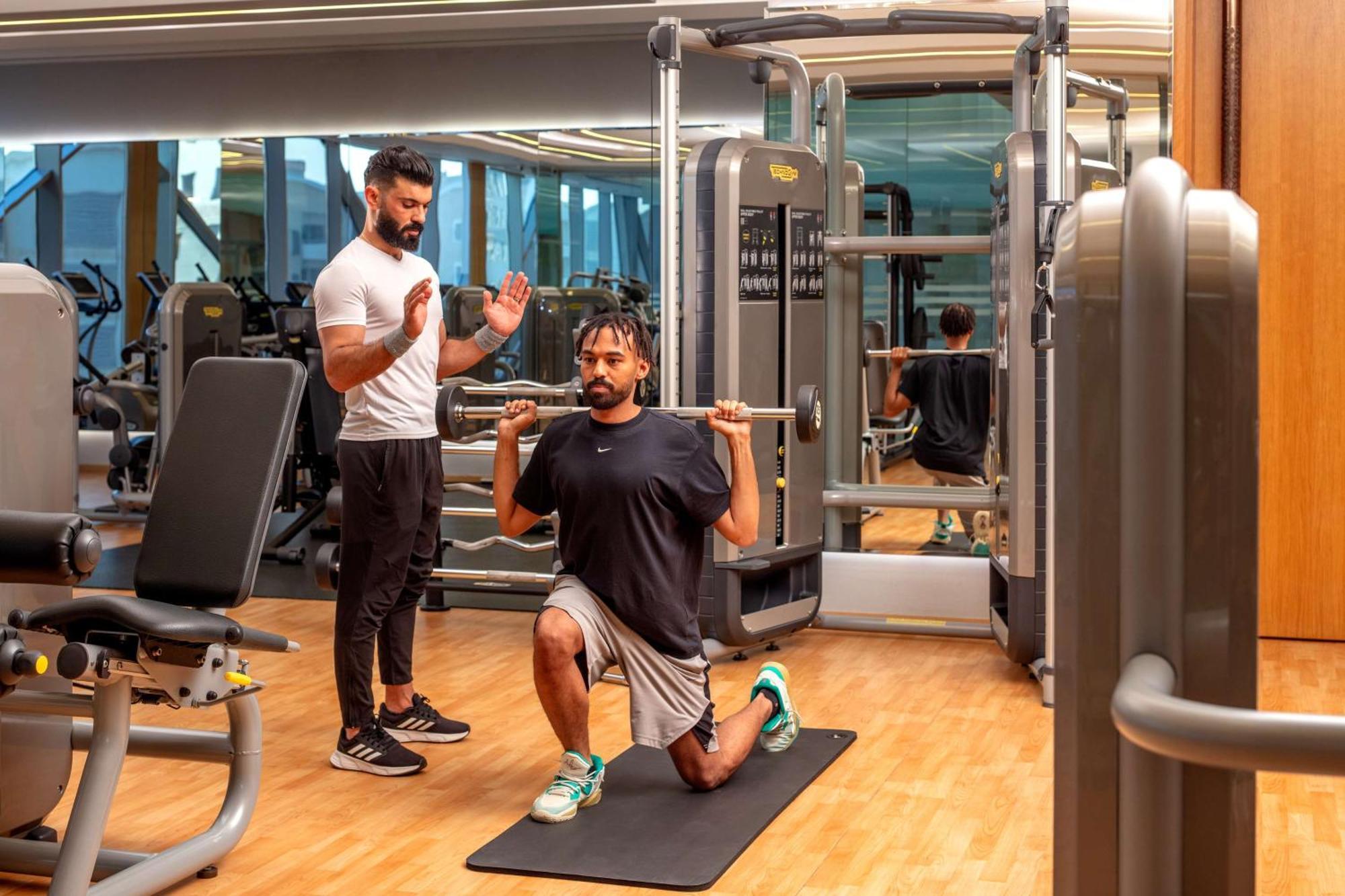Hyatt Regency Riyadh Olaya Zewnętrze zdjęcie Personal trainer coaching a man on a Bulgarian split squat